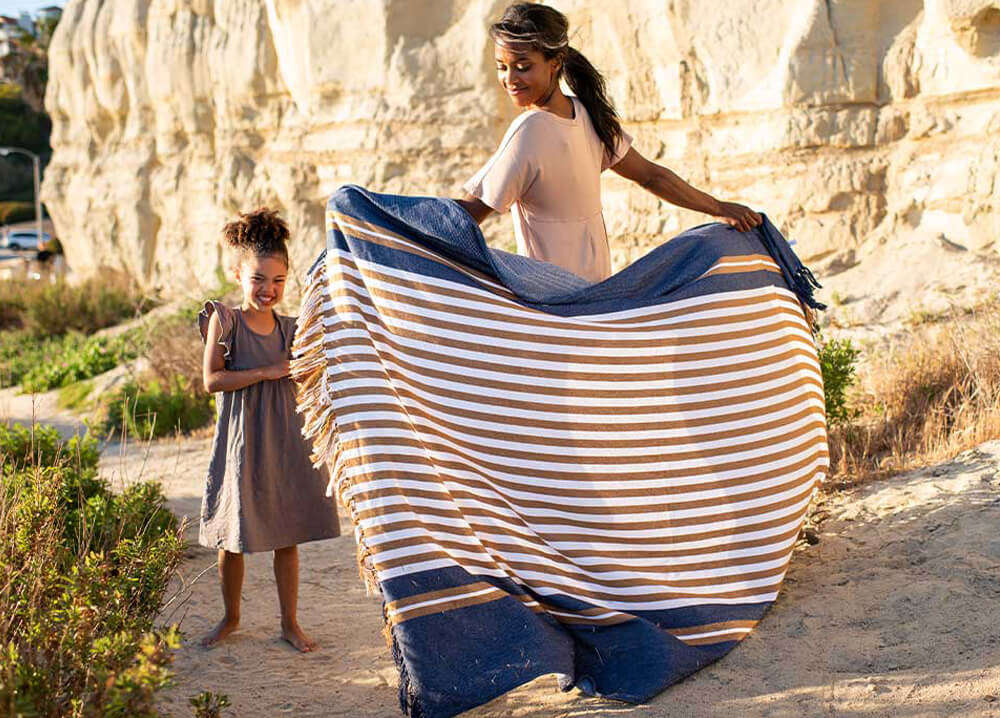 a women with striped throw standing in front of girl