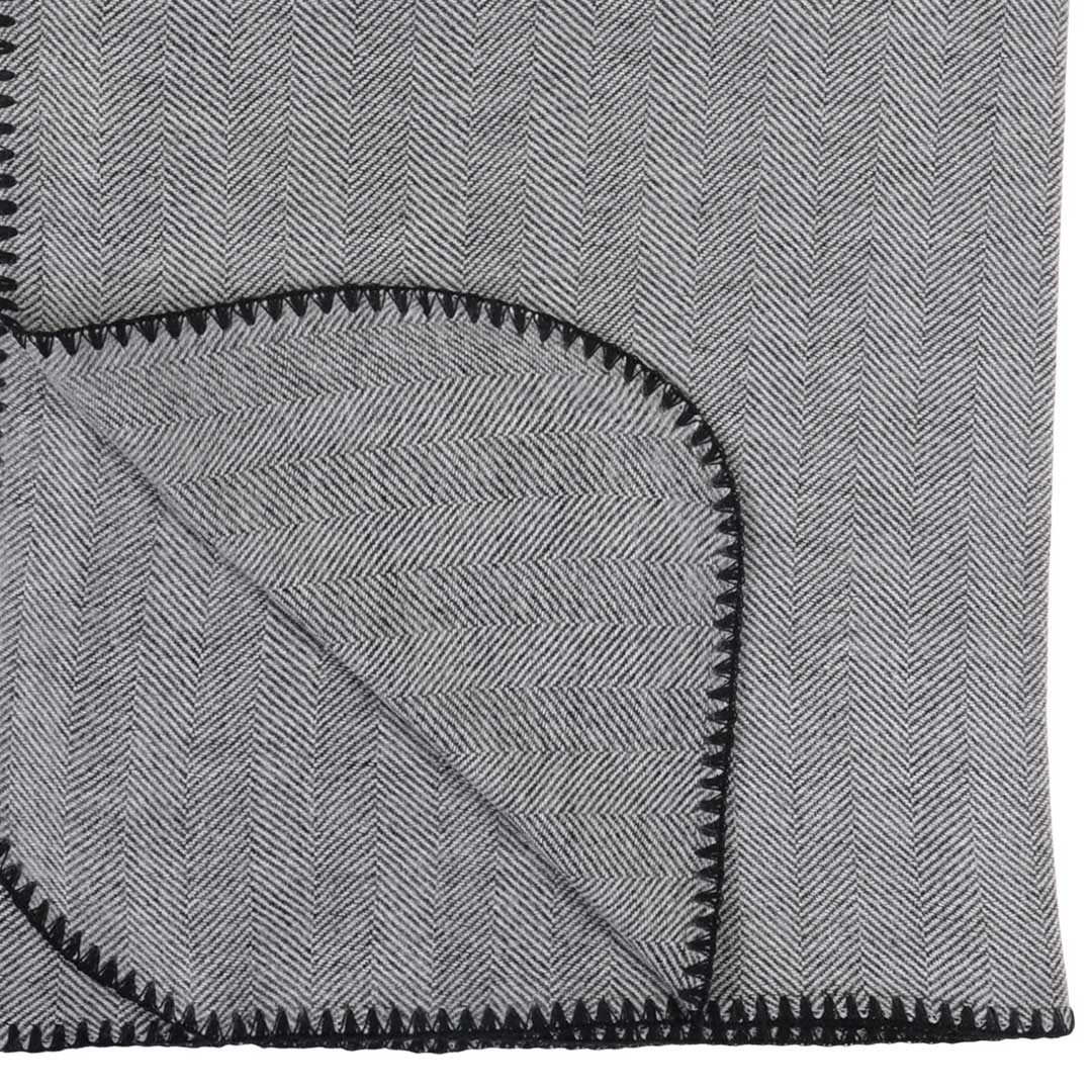 Winter Herringbone Blanket Black and Natural laying on bed