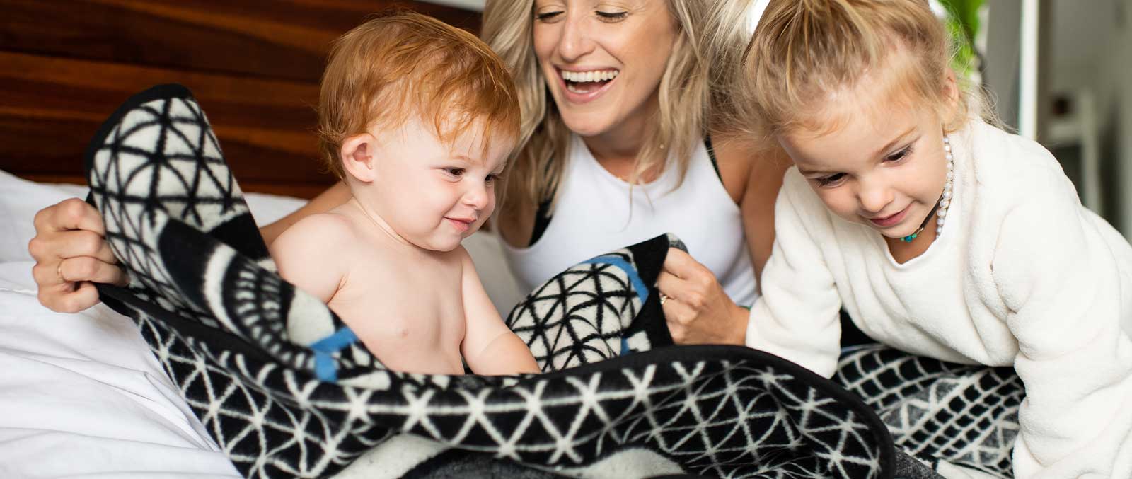 5 Best Cozy Blanket for any Occasion family on bed laughing and loving blanket