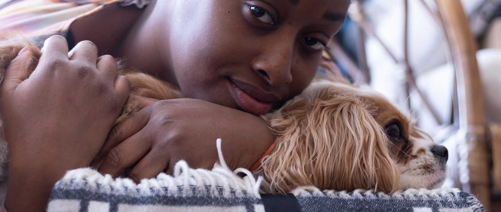 An african black women with puppy in her hands
