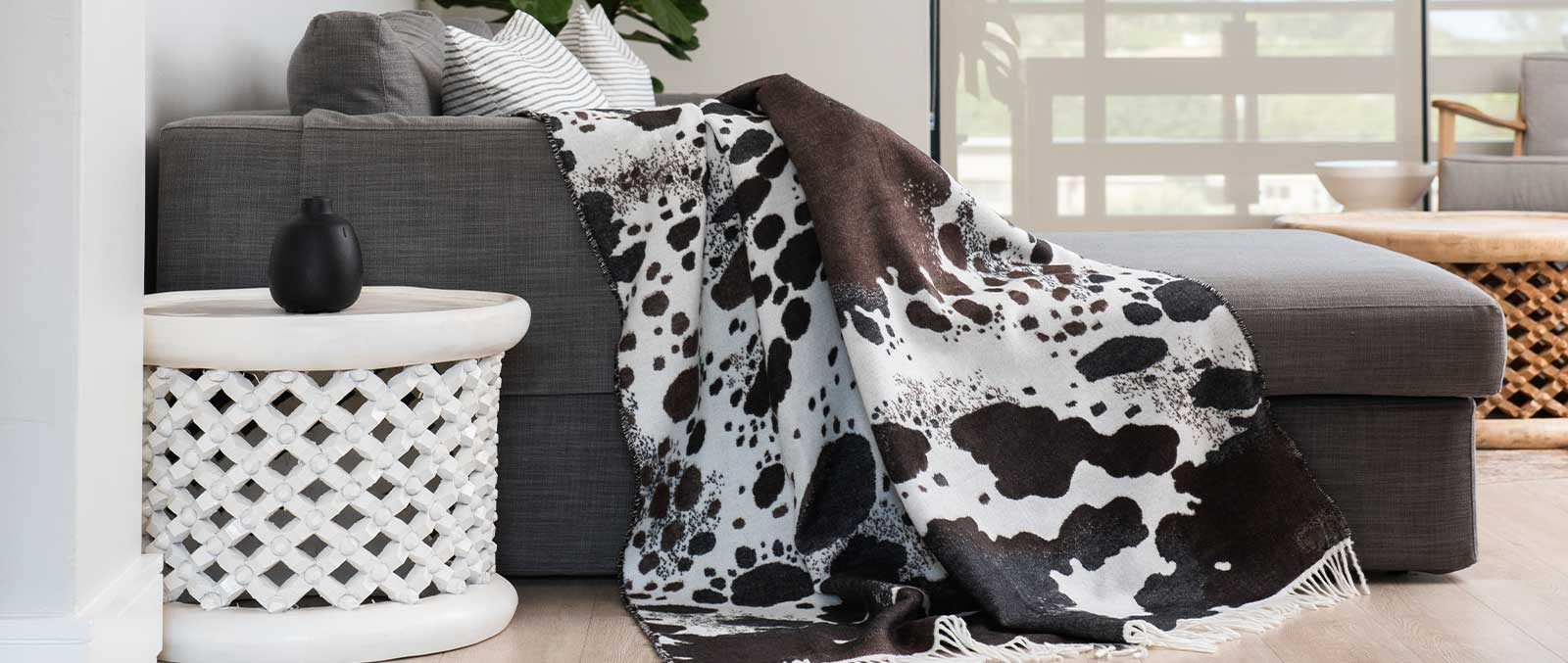 Ngnui cow print blanket lying on couch in contemporary home 