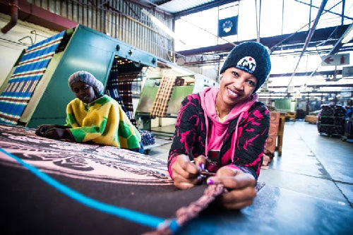 Thula Tula blankets African women smiling while working at the Thula Tula mill in Johannesburg south Africa 