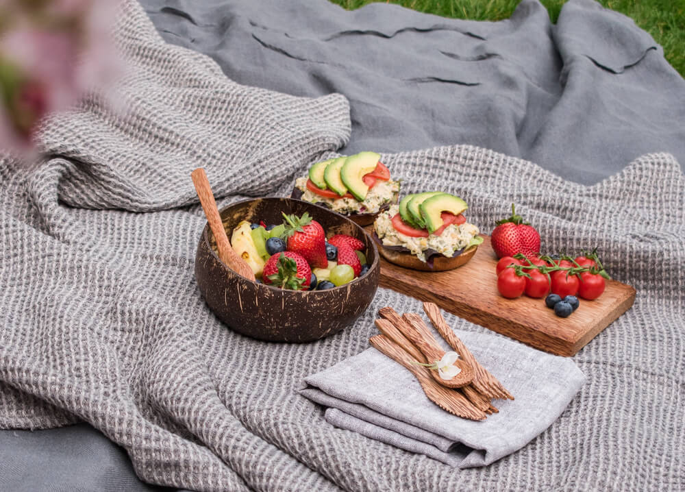 food dishes are placed on blanket in the picnic