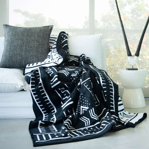 black and white Mali cotton suede Mud Cloth wrap, blanket or throw sustainably and ethically made in South Africa drapped over a modern House in South African home