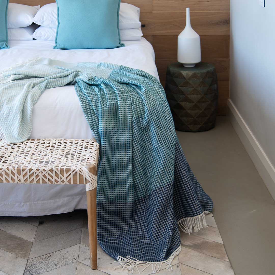 Lyric collection wrap, blanket or throw sustainably and ethically made in South Africa drapped over a bed in a modern house in South African home