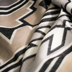 Extreme close up of Wild Dove colored Ndebele nation inspired wrap, blanket or throw sustainably and ethically made in South Africa incredibly soft, warm, and exceptionally durable blanket. The closeup shows the intricate weave and color combinations 
