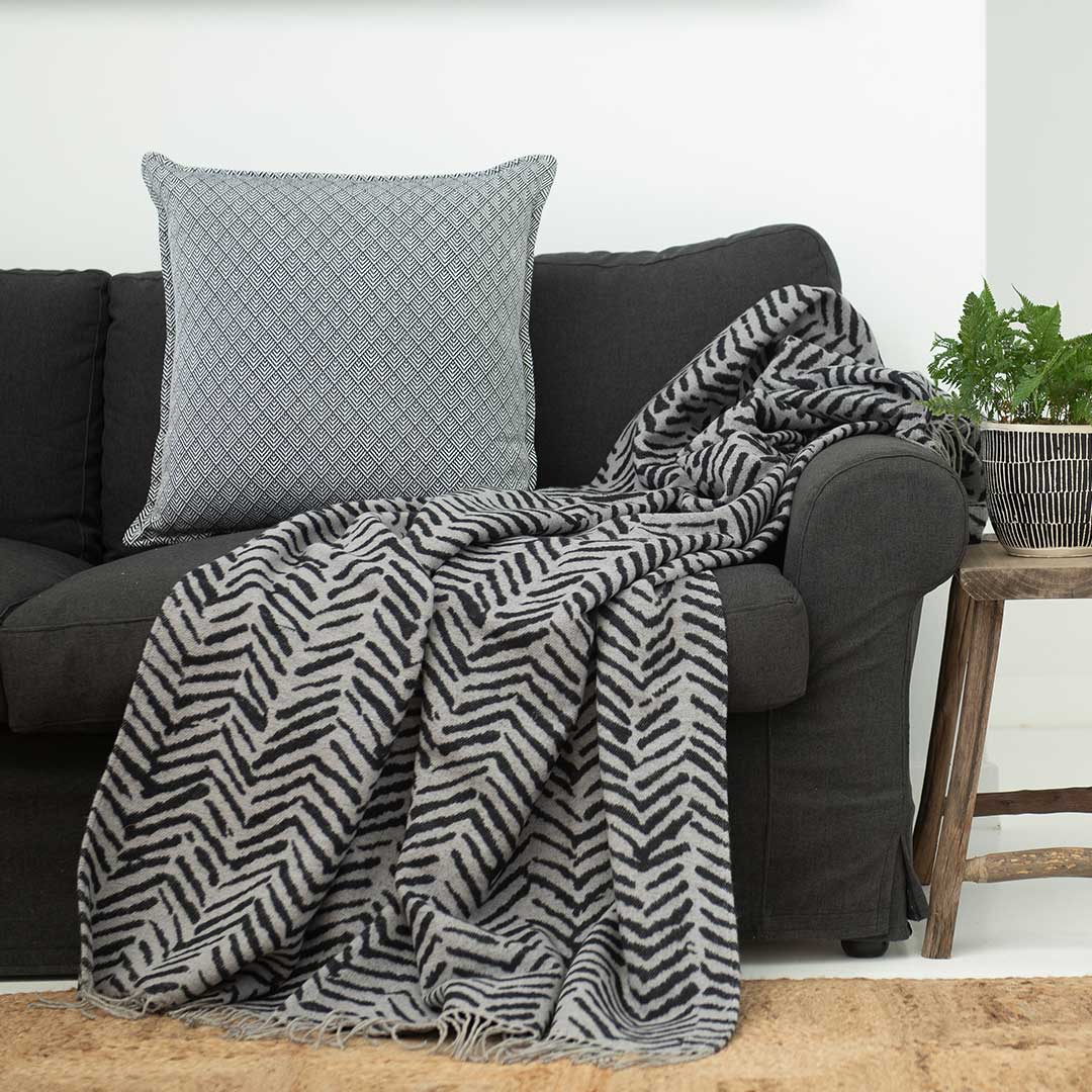Brush strokes wrap, blanket or throw sustainably and ethically made in South Africa drapped over a modern House in South African home