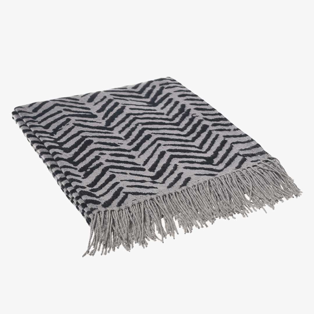 Folded brush strokes wrap, blanket or throw sustainably and ethically made in South Africa drapped over a modern House in South African home folded on white background