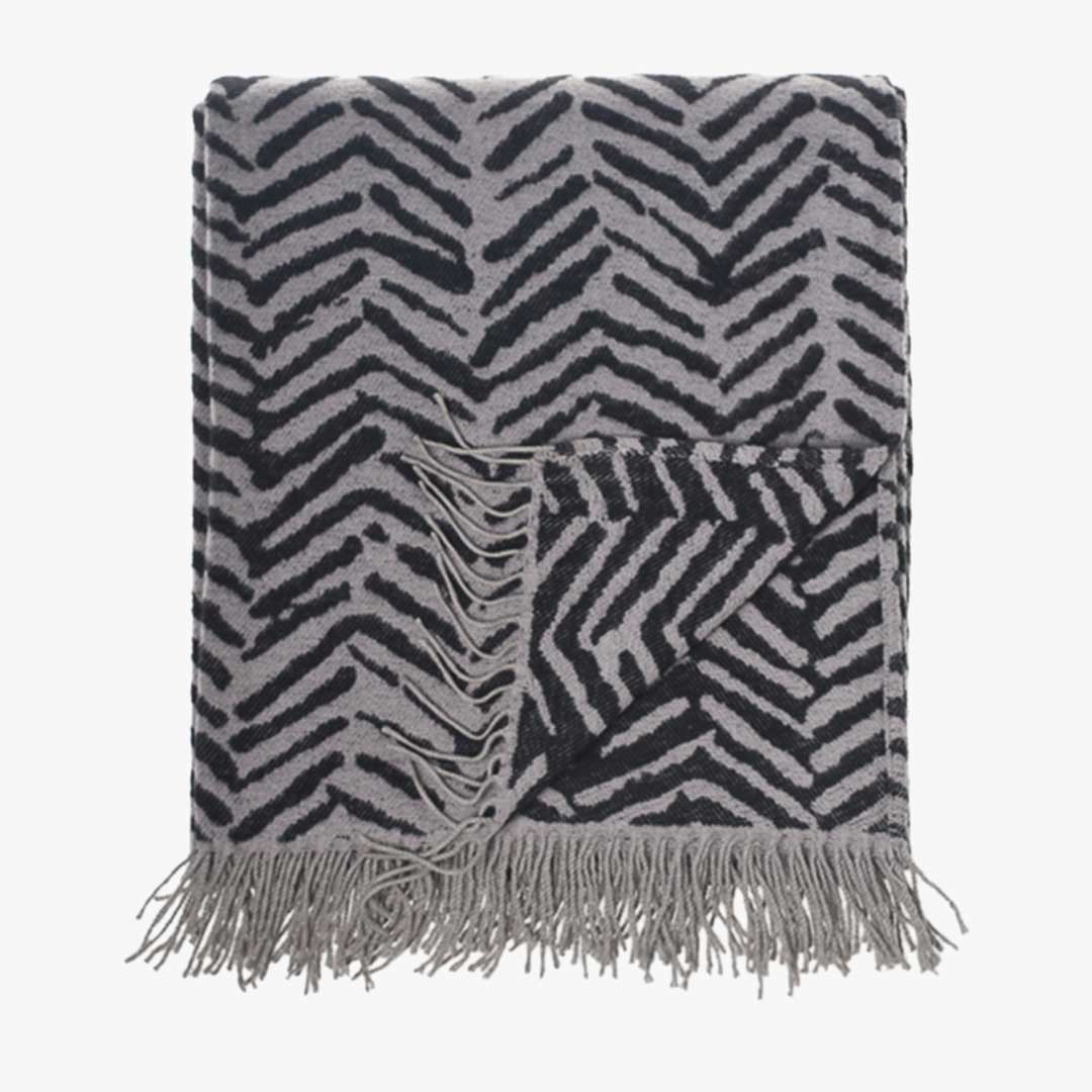 Brush strokes wrap, blanket or throw sustainably and ethically made in South Africa drapped over a modern House in South African home