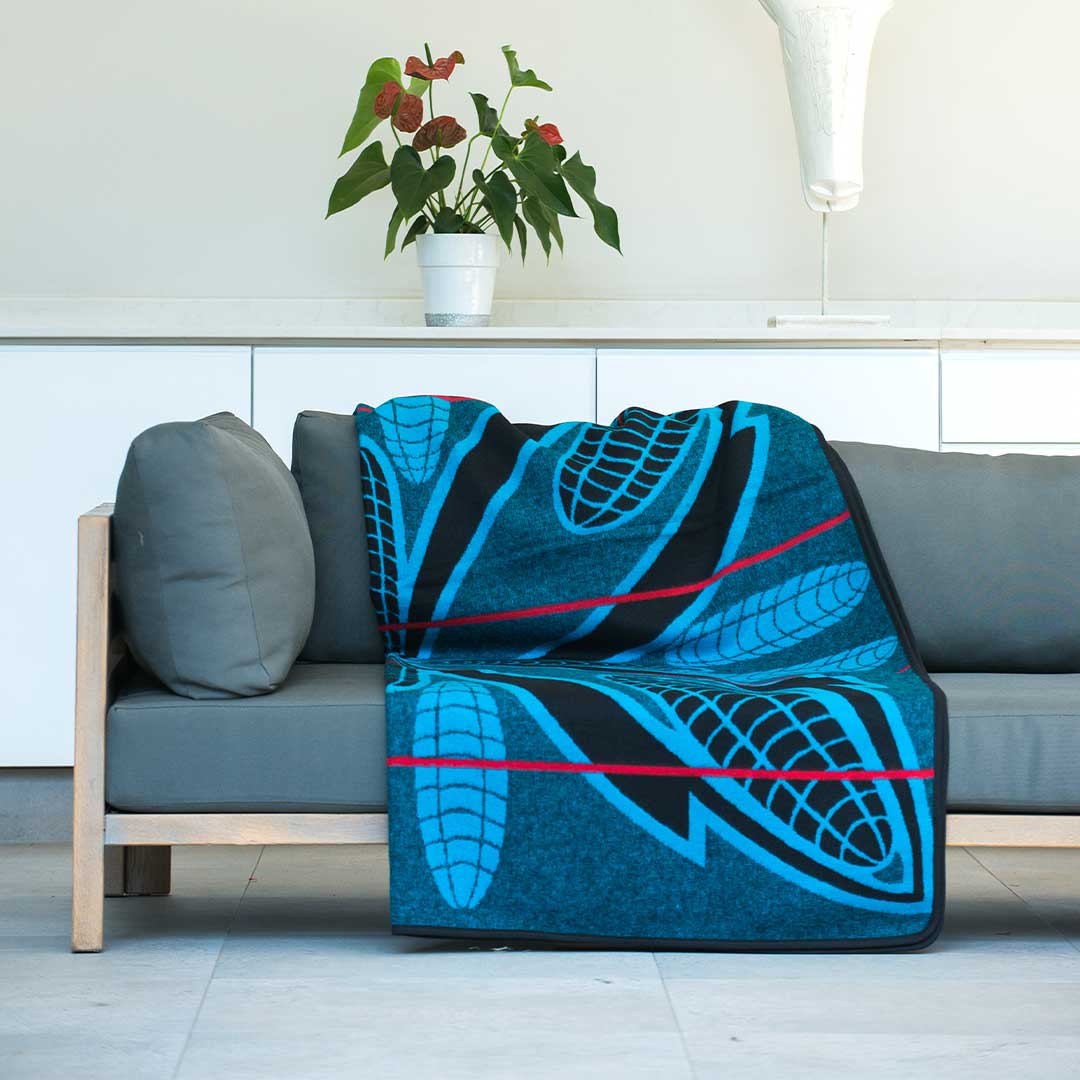 Heirloom Basotho Wool Blanket - Black & Peacock lying on sofa